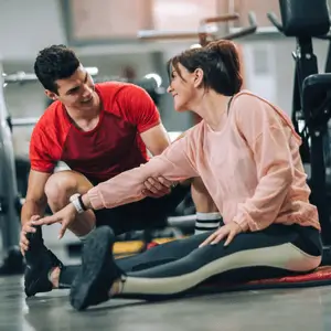 Trainer helps athlete stretch properly to recover from early signs of overtraining symptoms