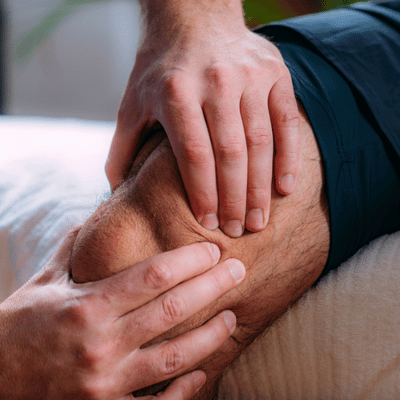 Therapist applying manual therapy on an athlete’s knee during physical therapy for athletes to improve recovery