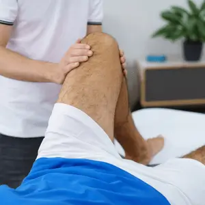 Therapist performs manual techniques during physical therapy after knee surgery to improve leg function