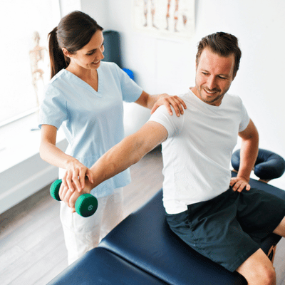 Therapist supports man's shoulder while lifting dumbbell as part of sports physiotherapy strengthening program session